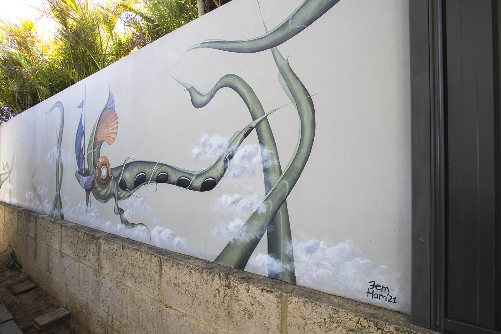 Outdoor mural of fantasy scene with diver's helment on green creature boat with sail